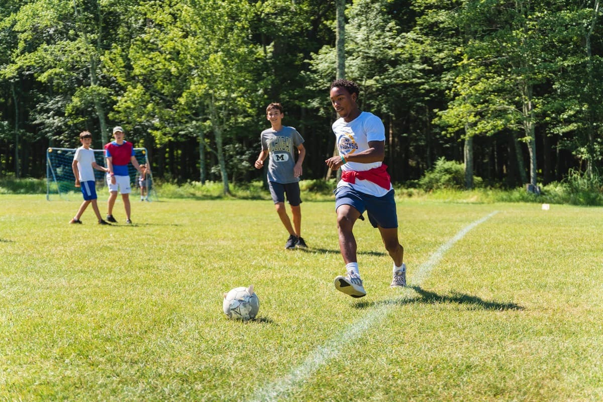 Campers playing soccer outdoors